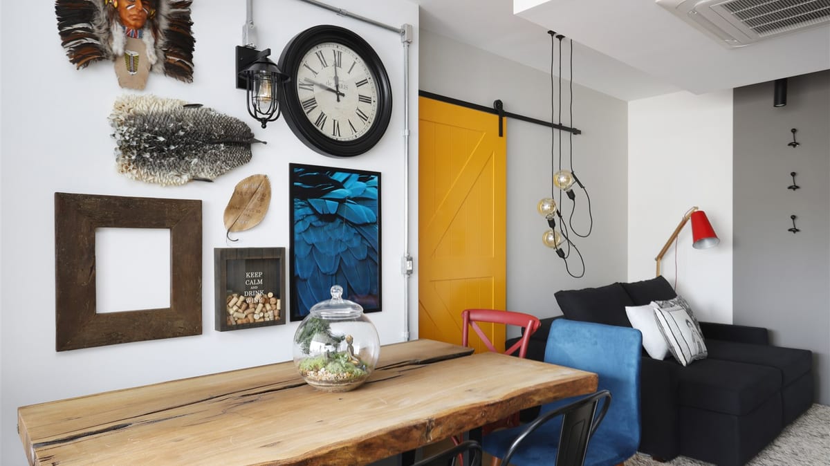 Sala de apartamento na Bela Vista reformada pela INSIDE, com mesa de madeira maciça, porta pivotante amarela e estante de aço, acervo INSIDE