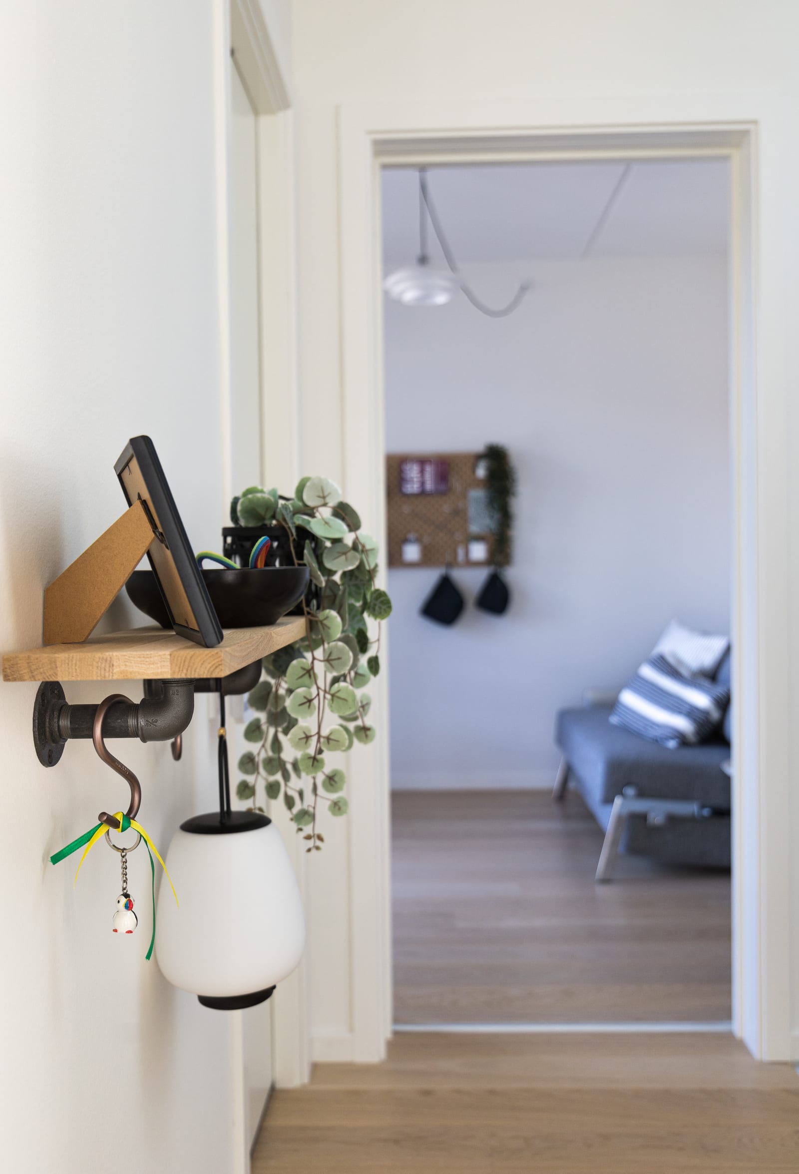Prateleira do hall com o chaveiro de tucano de fitas verde-amarelas, projeto INSIDE em Copenhague, 2022
