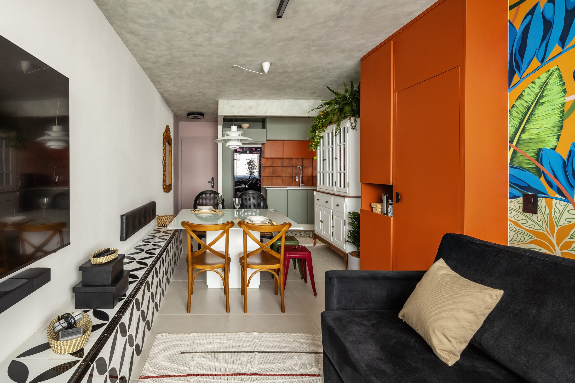 Área social integrada de Erick e Ben: sala, jantar e cozinha com marcenaria laranja, mural tropical e cozinha verde, projeto INSIDE