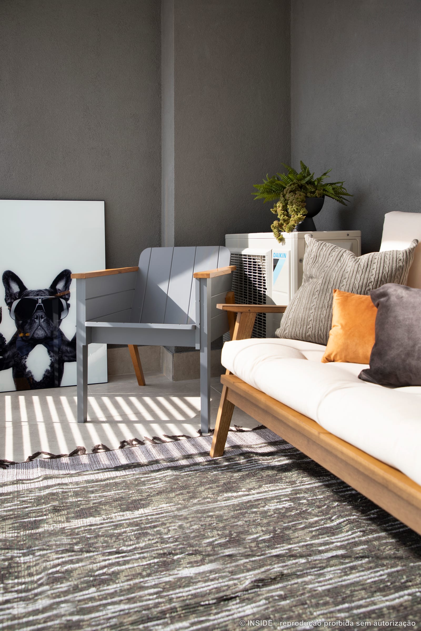 Estar com daybed, poltrona e o bulldog de decoração sobre o tapete listrado, apartamento alugado, projeto INSIDE