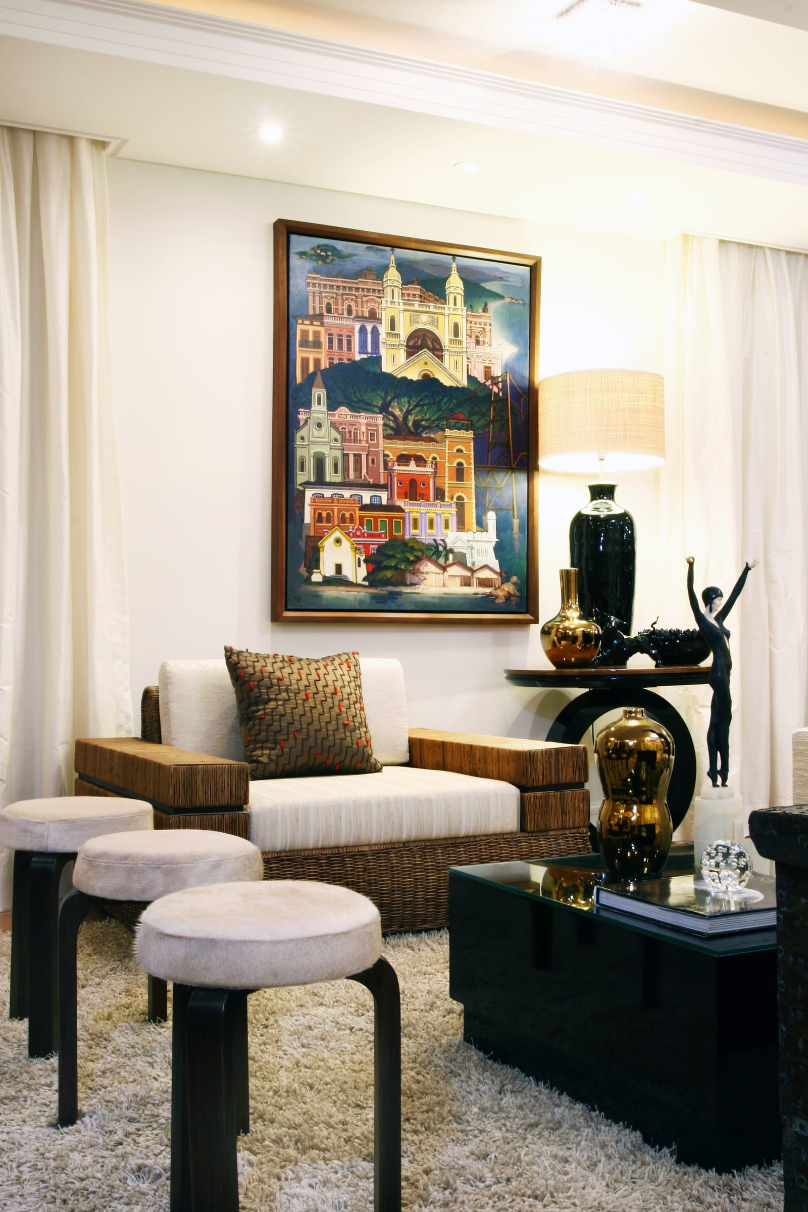 Canto de estar com quadro naïf do casario de Florianópolis, poltrona de fibra e aparador preto, projeto INSIDE